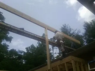 Carpenter setting a ridge beam over a new addition frame — Ice Dam Removal by Roofing Brothers in Castleton On Hudson