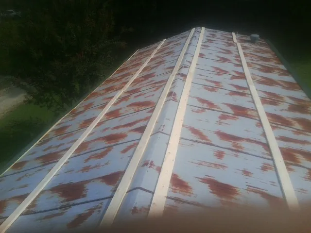 Rusted metal roof panels with new wood purlins before replacement — Storm Damage Roof Repair in Castleton On Hudson by Roofing Brothers