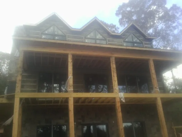 Dormers and porch framing on a large log home under construction — Roof Coating work by our crew in Castleton On Hudson