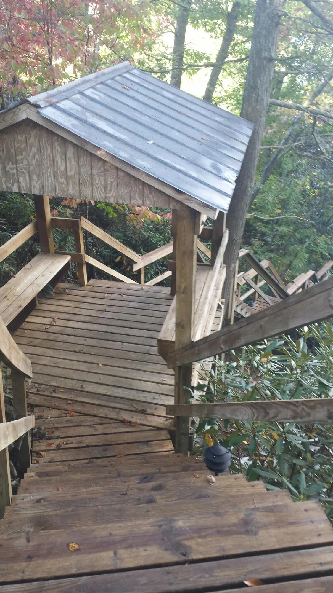 Metal roofed shelter over wooden steps on a wooded walkway — Skylight Repair & Installation work by our crew in Castleton On Hudson